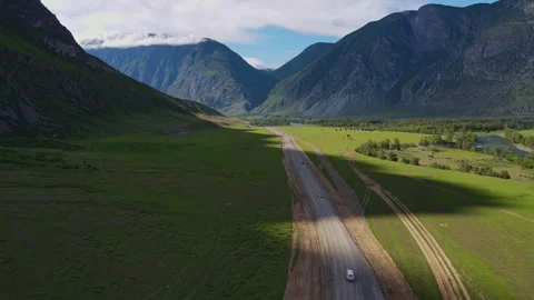 Road and car against the backdrop of a mountain landscape in summer Stock Footage 247392284