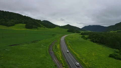 Road and car against the backdrop of a mountain landscape in summer Stock Footage 247392305