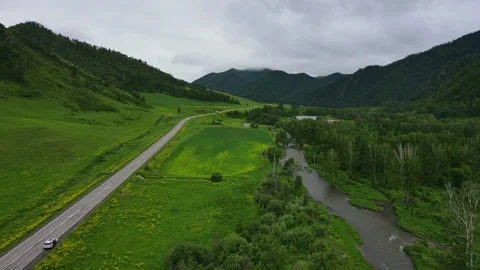 Road and car against the backdrop of a mountain landscape in summer Stock Footage 254436101