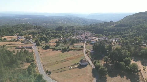 Road and dry fields toward Eiradela among wooded hills, Ourense aerial Stock Footage 348714787