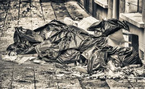 Road and footpath full of garbage in the city center, dirty street concept Stock Photos