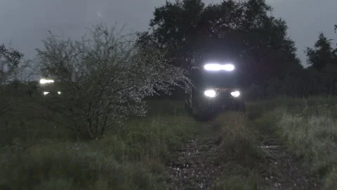 Off Road ATVs or UTVs Driving in the Rain with Bright Headlights Stock Footage 323405550
