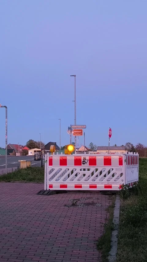 Road barrier with signal lights at an intersection at dusk. Stock Footage 347417780