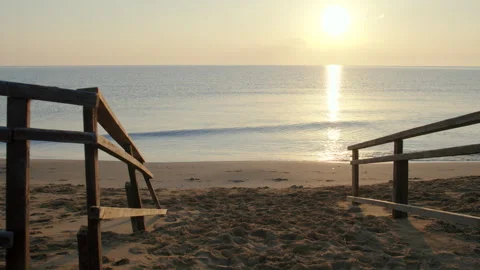 Road to the beach over the old bridge, footprints on the sand, sunset on the sea Stock Footage 303827629