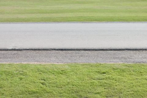 Road between green grass. Stock Photos