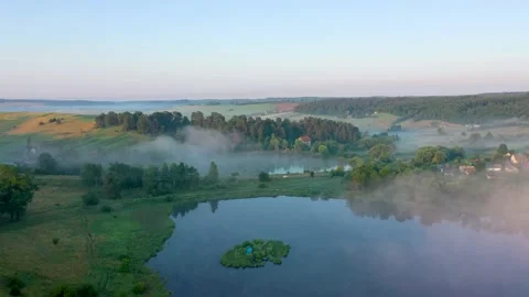 Road between two lakes in morning fog Stock Footage 158008389