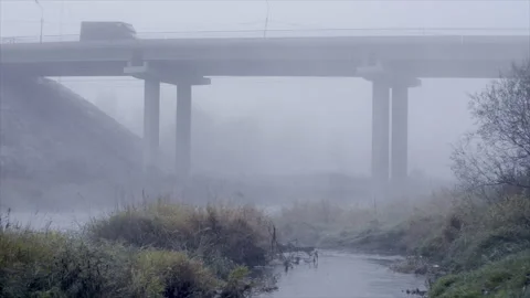 Road bridge over the river in dense fog Stock Footage 221759186