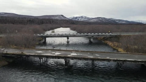 A road bridge passing through a mountain river. aerial drone footage Stock Footage 280381763