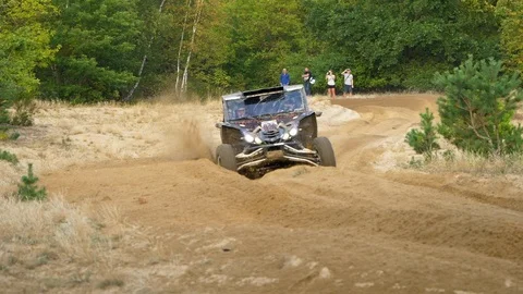 Off-road buddy taking a sharp turn, kicking up sand as it speed passes Stock Footage 122279429