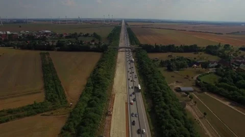 Road build construction widen multilane highway wind turbines transport traffic Stock Footage 67271793