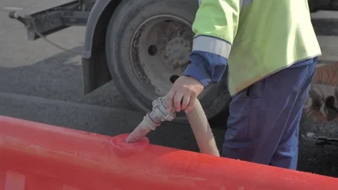 Road builder draws water into a plastic fence Stock Footage 285143619