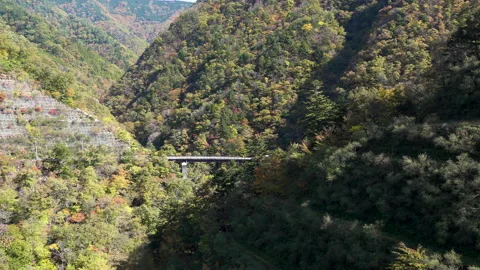 A road that can be seen in the distance in the autumn mountains Stock Footage 164423143