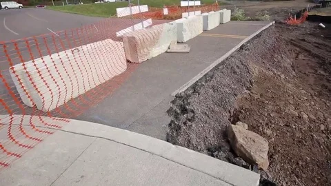 Road Closed! Sliced Road Reveals Paved Layers above Dirt with Concrete Barrier Stock Footage