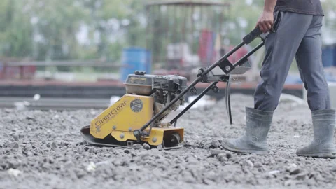 Road compaction performed with powerful vibratory plate Stockbeeldmateriaal 329830783