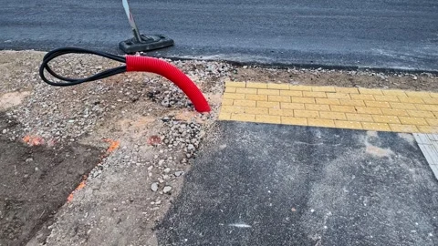 Road construction with asphalt paving and laying fiber optic cables in a Stock Footage 335892799