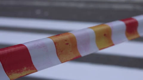 Road construction in city, passage is close, warning barrier tape flutters Stock Footage 336472340