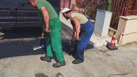 Road construction crew manually laying asphalt using rakes and shovels. Close Vídeo Stock 301780685