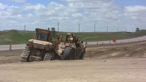 Road Construction dozer pushes earthmover - another dozer crosses Stock Footage 104829883