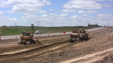 Road construction -A dozers then big earthmover to camera Stock Footage 104829545