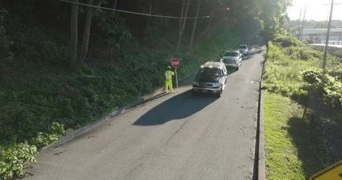 Road Construction Flagger Directing Traffic Along Road Holding Slow / Stop Sign 動画素材 201281900