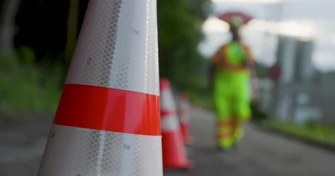 Road Construction Flagger Walking with Stop / Slow Sign Past Traffic Cones Stock-Footage 201282401