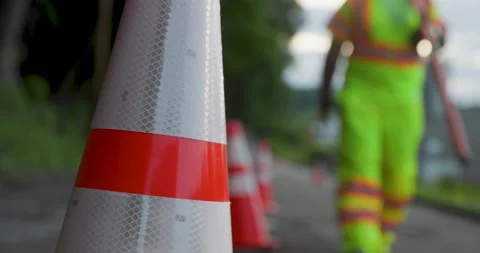Road Construction Flagger Walking with Stop / Slow Sign Past Traffic Cones Vídeo Stock 201282411