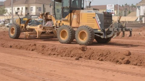 Road construction grader leveling dirt surface during infrastructure development 動画素材 325853480
