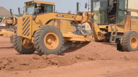 Road construction grader leveling dirt surface during infrastructure development 動画素材 325853486