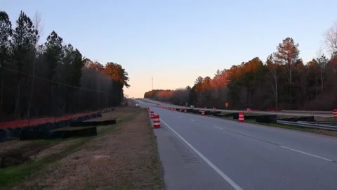 Road construction highway with road work signs and cones in the evening Stock Footage 147518952