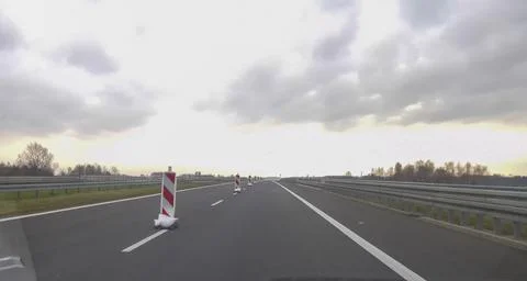 Road construction scene featuring traffic cones and warning signs placed on an Stock Photos