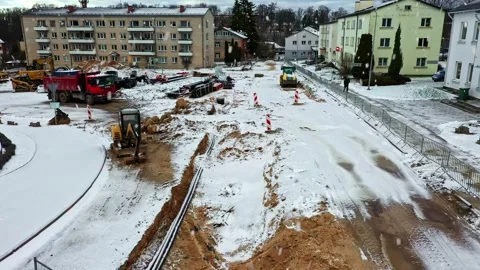 Road construction site during a winter snowfall with heavy machinery Stock Footage 346595206