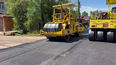 Road construction site. The yellow roller is seen working Video stock 289305638