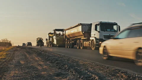 Road construction at sunset. Loading asphalt mixture into an asphalt paver Stock-Footage 142523592