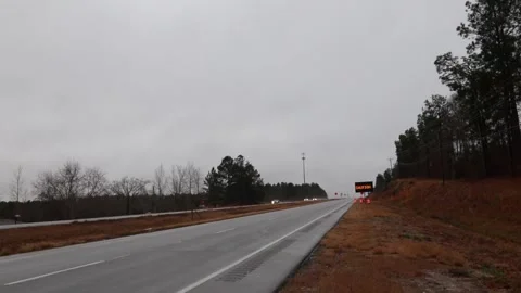 Road construction warning mobile LED display sign and traffic ona rainy cloud Stock Footage 148959134