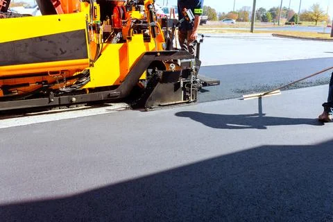 Road construction work involves asphalt paving with machines workers in par.. Foto stock