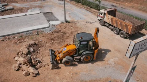 Road construction work. Mini loader removes stones and ground into the dump Stock Footage 50748283