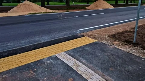 Road construction work with newly laid asphalt and tactile paving at sunset Stock Footage 341457372