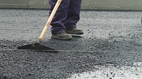 Road construction worker leveling asphalt using rake on the new road Vidéo 51329802