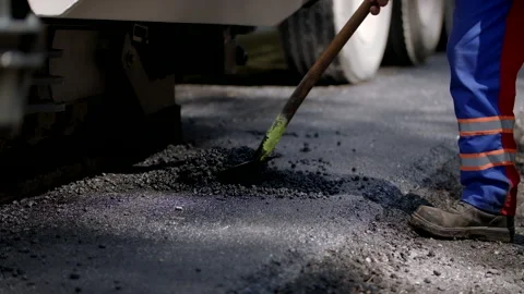Road Construction Worker Is Shovelling A Small Pile Of Tarmac Stock Footage 142002816