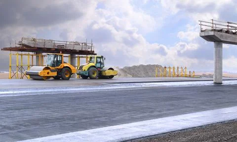 Road construction with yellow road rollers when paving asphalt Stock Photos