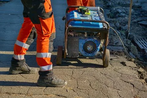 Road construction.Worker prepare to start generator with actuator cord Stock Photos
