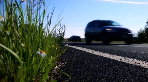 Road in the countryside next to the grass - sunny day Stock Footage