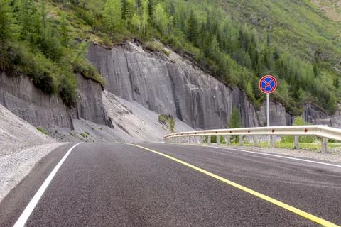 Road covered with asphalt with markings a solid line and a sign prohibiting t Stock Photos