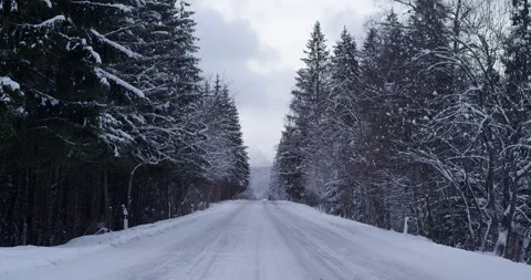 Road covered with snow with mountains in background. overcast Stock Footage 147640657