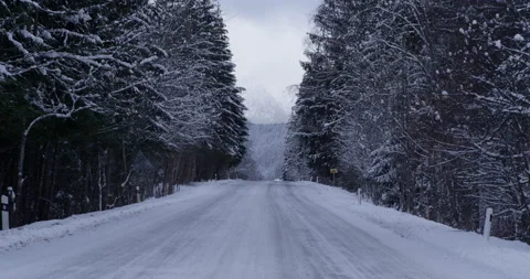 Road covered with snow with mountains in background. overcast Stock Footage 147641188