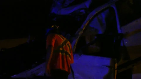 Road crew guy examining crash that left car in a very unlikely position Stock Footage 141222463