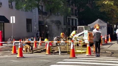 Road crews do major roadwork on a street in New York City while pedestrians wait Video stock 142842013