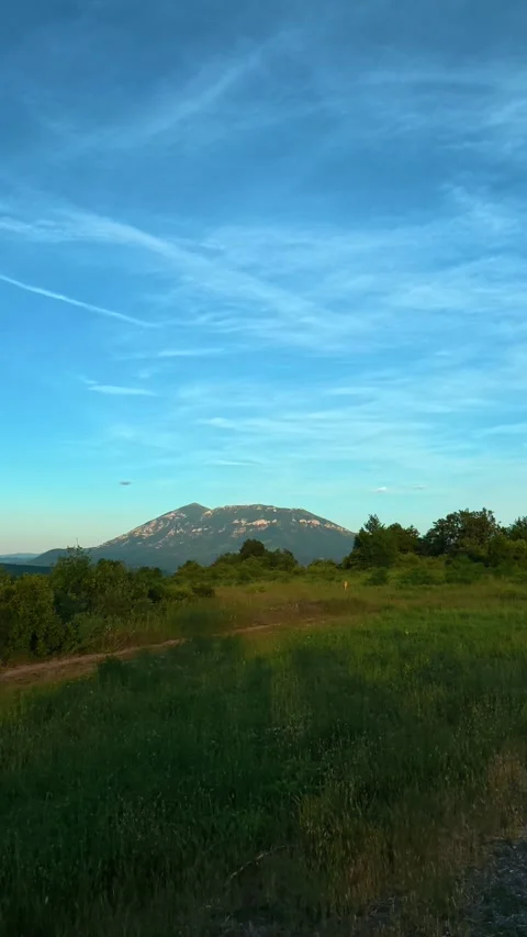 Road curves gently through green fields. Mount Rtanj Area. Vertical Stock Footage 340899100