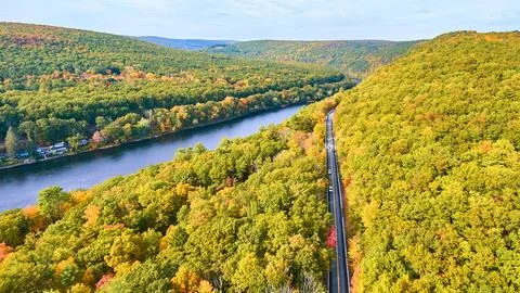 Road cutting through early fall forest along Delaware River from drone Stock Photos