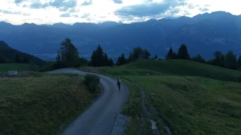 Road Cyclist Descending Steep Road Above Alpine Valley Stock Footage 344584801